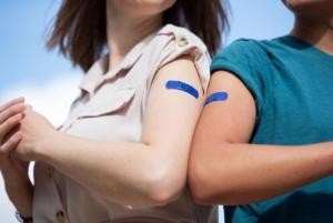 Náplasti s vlajkou EU na rameni mladých lidí po očkování ©EC Audiovisual Service